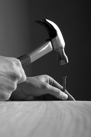 carpenter hammering a nail into a board