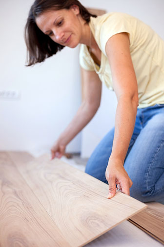 woman installing laminate flooring